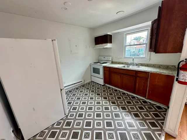 a kitchen with a refrigerator a sink a stove a microwave and cabinets