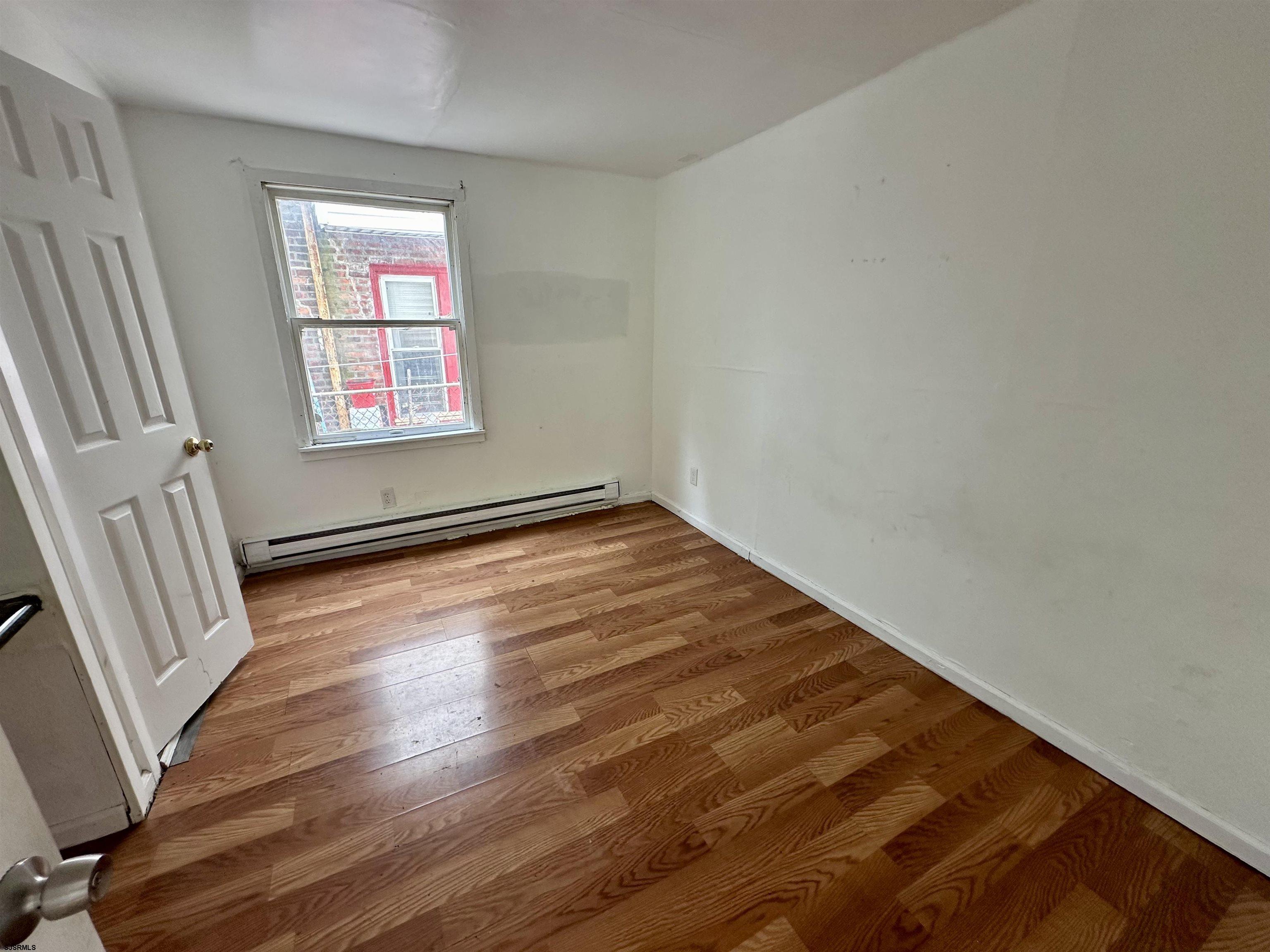 2521 Centennial Avenue, Unit 1 Atlantic City, NJ 08401 - Photo 6 of 8 an empty room with wooden floor and windows