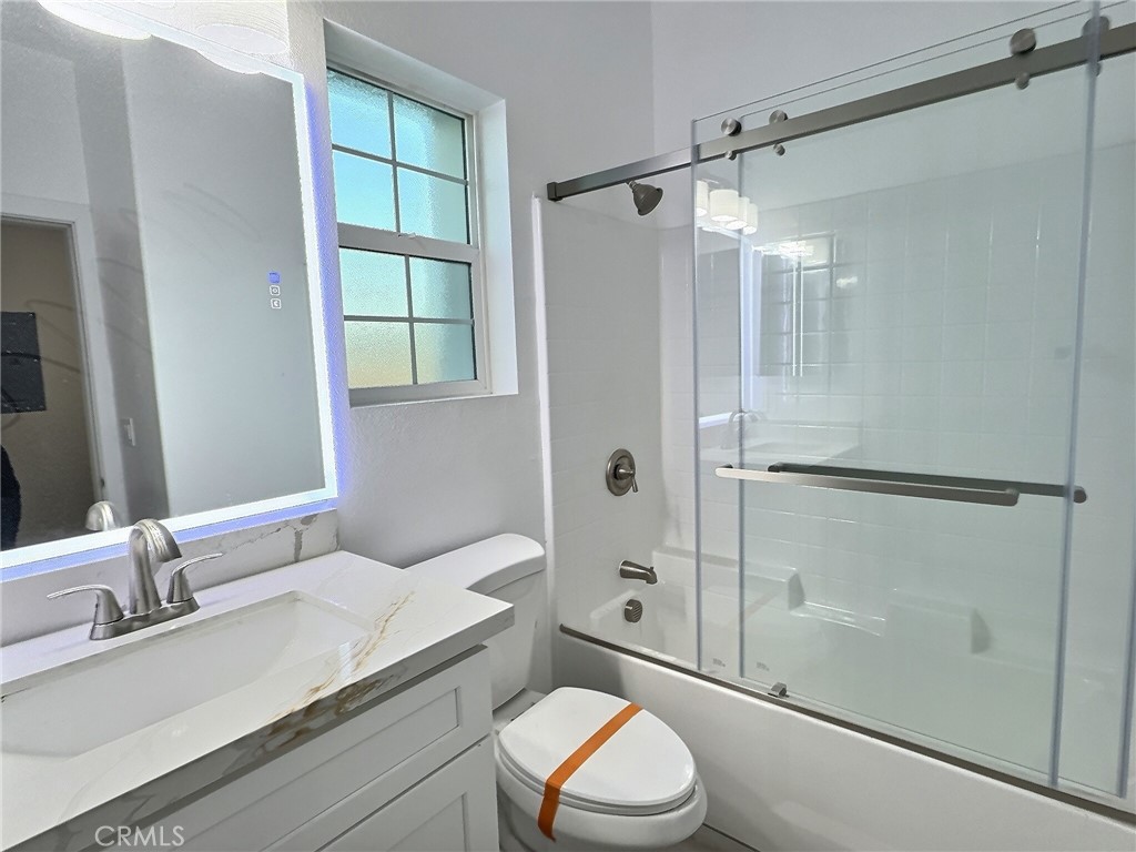 15909 Merrill Avenue, Unit 1 Fontana, CA 92335 - Photo 6 of 7 a bathroom with a granite countertop sink toilet and shower