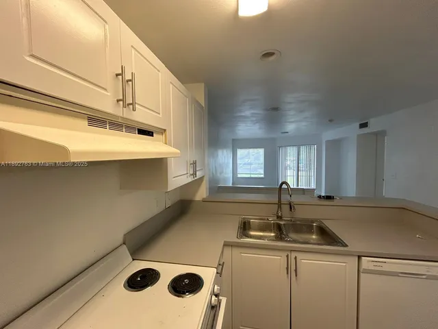 a kitchen with a sink and a refrigerator
