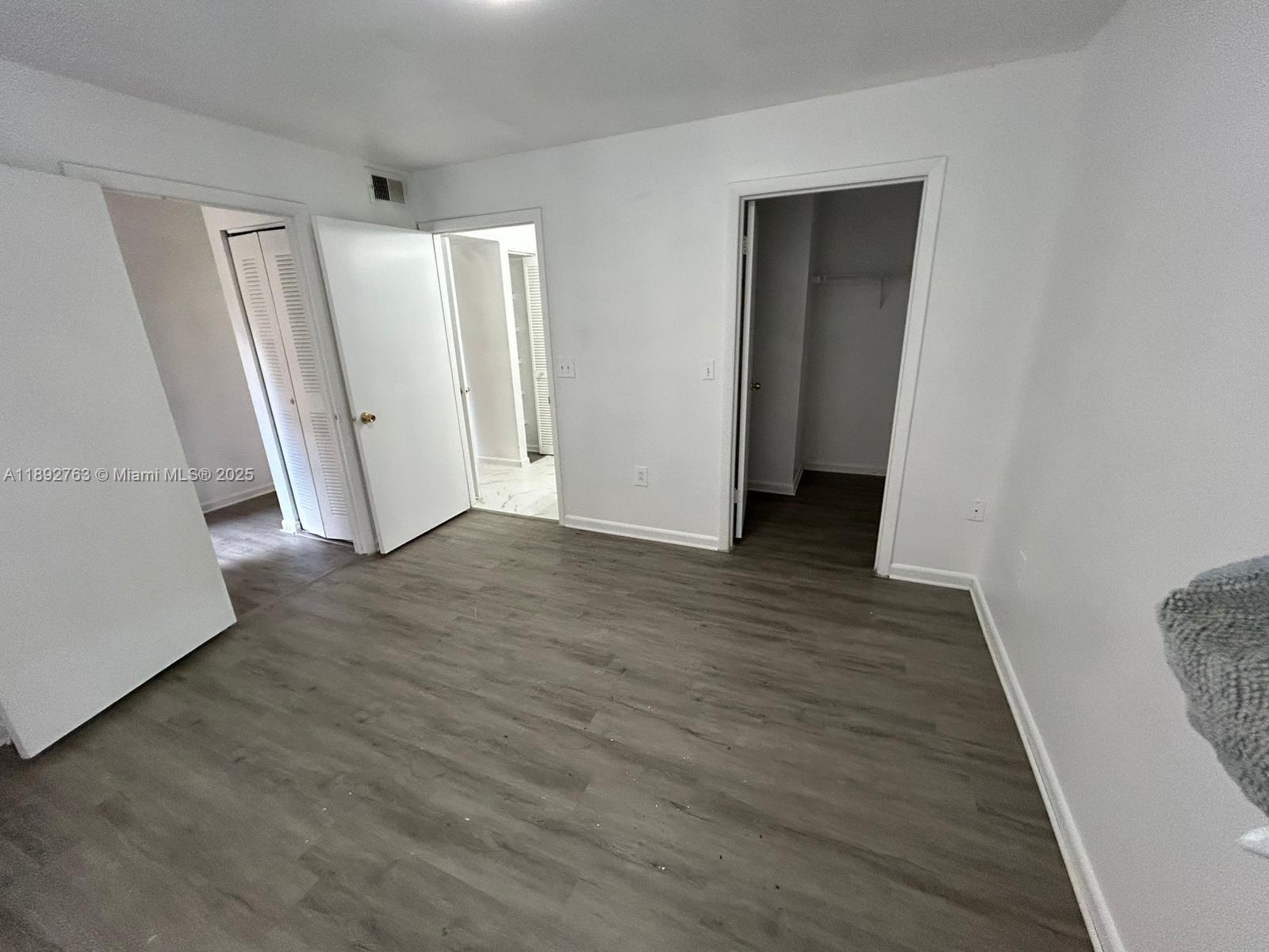 4815 Via Palm Lakes, Unit 1411 West Palm Beach, FL 33417 - Photo 6 of 11 an empty room with wooden floor and entrance