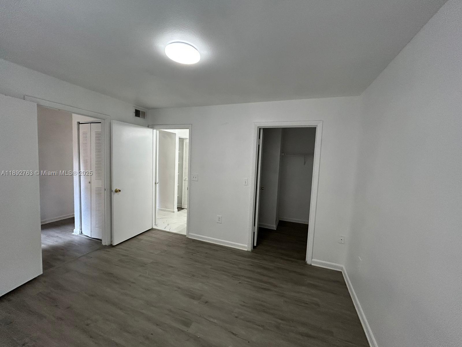 4815 Via Palm Lakes, Unit 1411 West Palm Beach, FL 33417 - Photo 7 of 11 a view of an empty room with wooden floor and closet