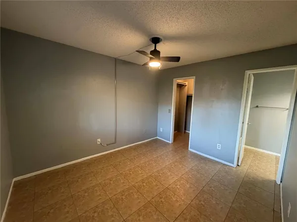 an empty room with closet and a chandelier fan