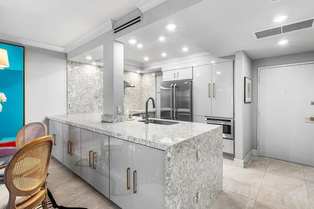 a bathroom with a granite countertop sink a mirror and a shower