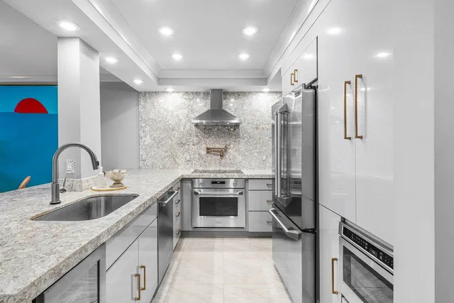 a kitchen with stainless steel appliances granite countertop a sink stove and refrigerator