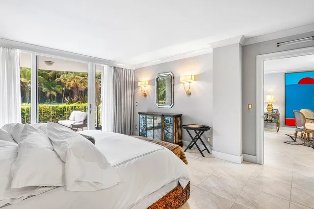 a bedroom with a bed mirror and a window