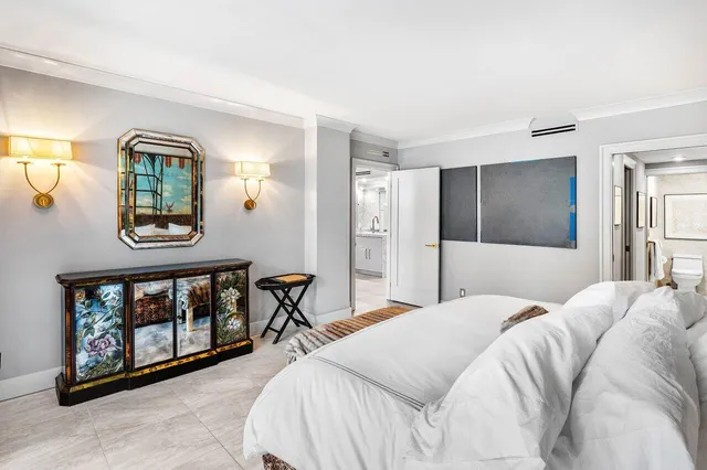 a bedroom with a bed painting on wall and a window