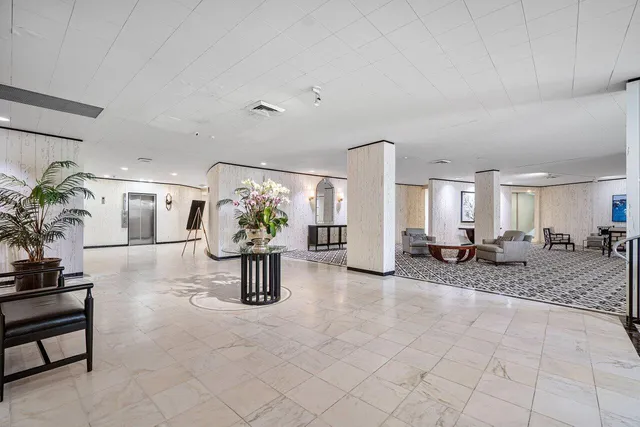 a living room with furniture a chandelier and a fireplace