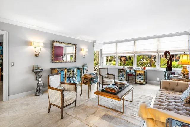 a living room with furniture kitchen view and large windows