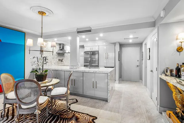 a kitchen with a dining table chairs and white cabinets