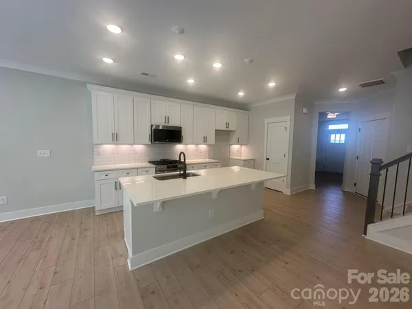 a kitchen with stainless steel appliances granite countertop a sink refrigerator and microwave