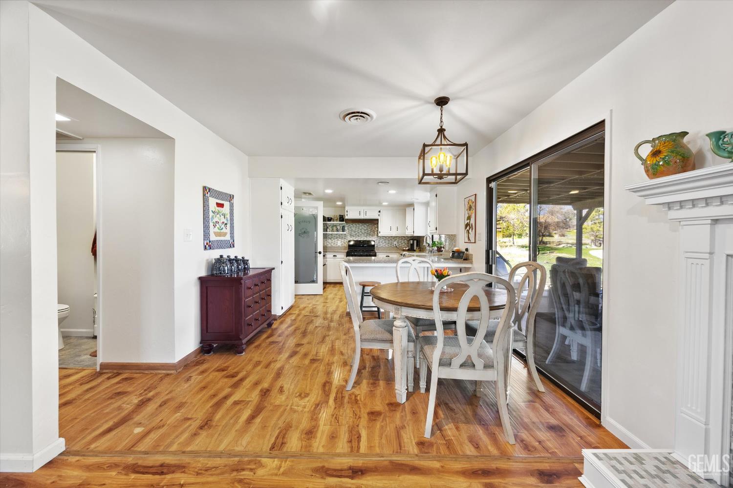 Undisclosed Address Tehachapi, CA 93561 - Photo 15 of 48 a dining room with wooden floor a chandelier a wooden table and chairs