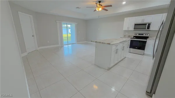 a kitchen with granite countertop a refrigerator and a stove top oven
