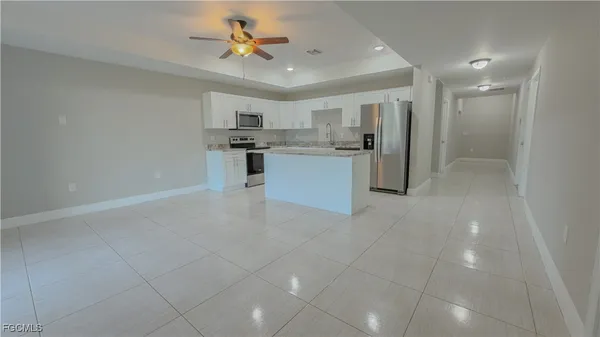 a large kitchen with kitchen island a sink stainless steel appliances and cabinets
