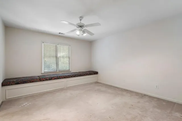 a view of an empty room with wooden floor and cabinets