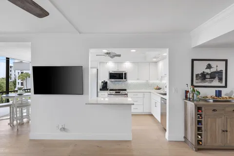 a living room with stainless steel appliances kitchen island furniture and a flat screen tv