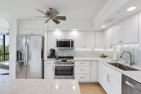 a kitchen with white cabinets and stainless steel appliances