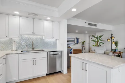 a kitchen with white cabinets and sink