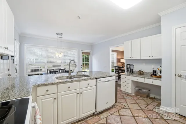 a kitchen with white cabinets and sink