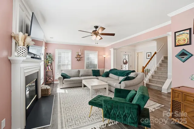 a living room with furniture a fireplace and a chandelier