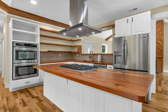 a kitchen with stainless steel appliances granite countertop a stove and a refrigerator