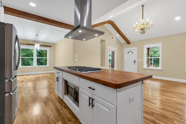 a kitchen with stainless steel appliances granite countertop a stove and a chandelier