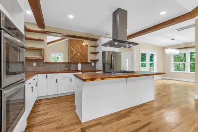 a large kitchen with stainless steel appliances double vanity and a large window