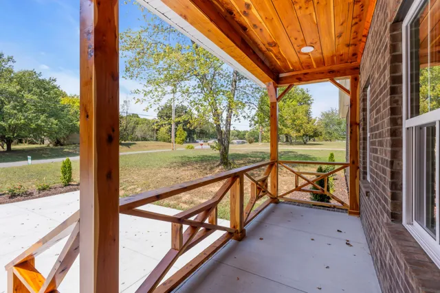 a view of a porch with wooden floor and fence