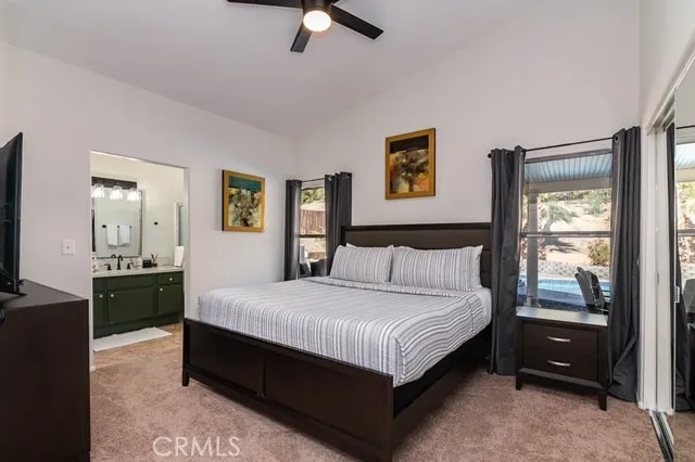 a large bedroom with a bed and a dresser next to a window