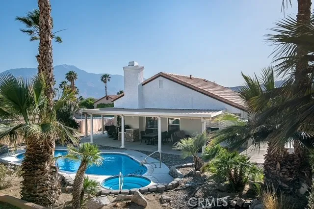 a front view of a house with a yard and potted plants