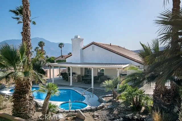 a view of house with a yard and potted plants