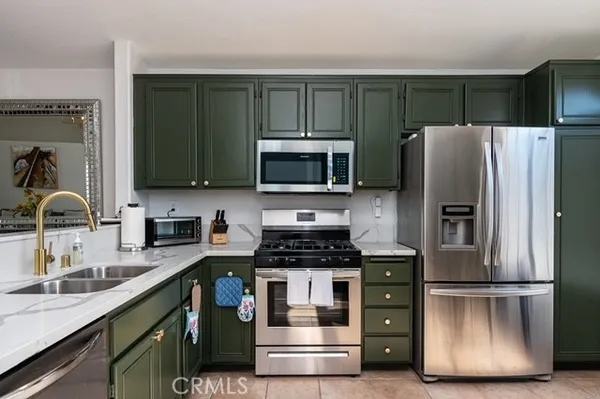 a kitchen with kitchen island granite countertop stainless steel appliances and a refrigerator