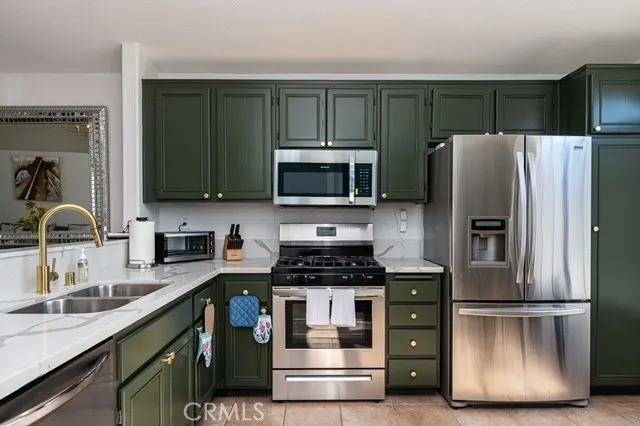 a kitchen with kitchen island granite countertop stainless steel appliances and a refrigerator