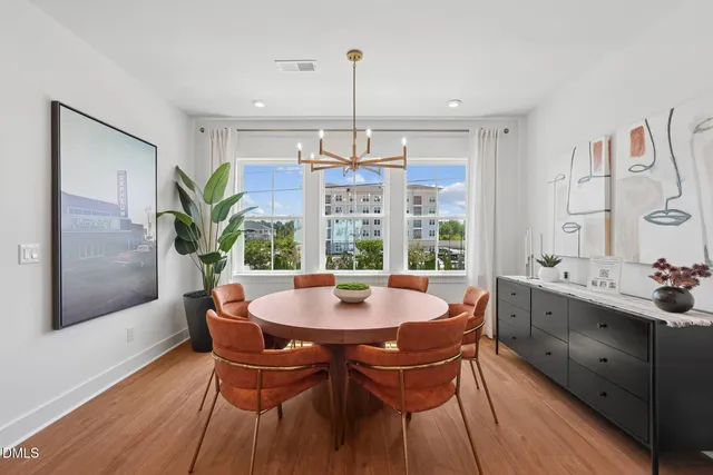 a kitchen with a stove a sink a kitchen island with a dining table and chairs