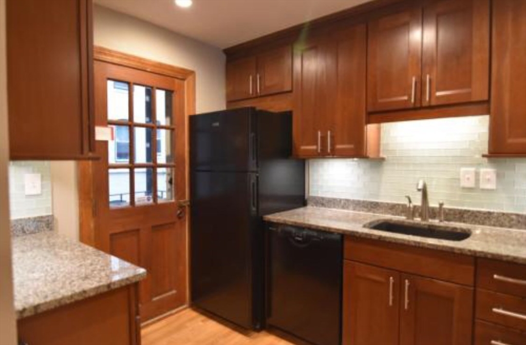 84 Gordon Street, Unit 206 Boston, MA 02135 - Photo 7 of 15 a kitchen with granite countertop cabinets and window