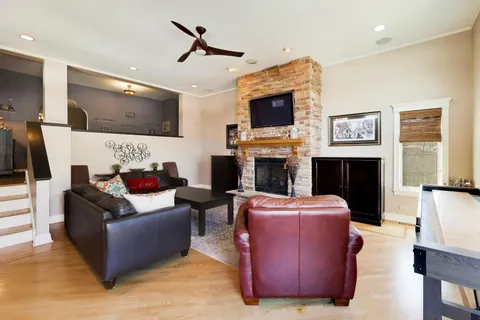 a living room with furniture a flat screen tv and a fireplace