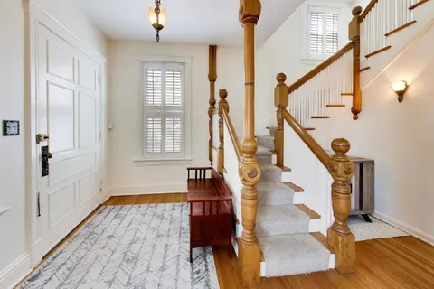 a view of an entryway with wooden floor and staircase