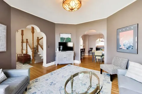 a living room with furniture a flat screen tv and a large window