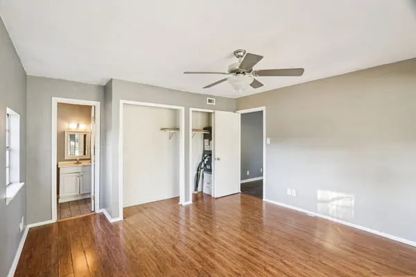 a view of empty room with wooden floor and ceiling fan