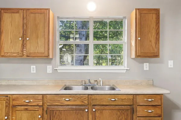 a kitchen with granite countertop cabinets sink and window