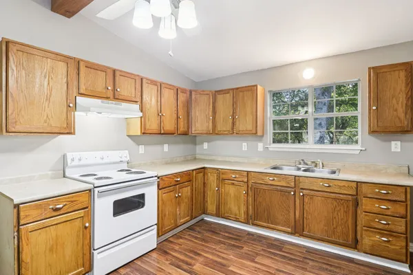 a kitchen with a white stove top oven sink and cabinets
