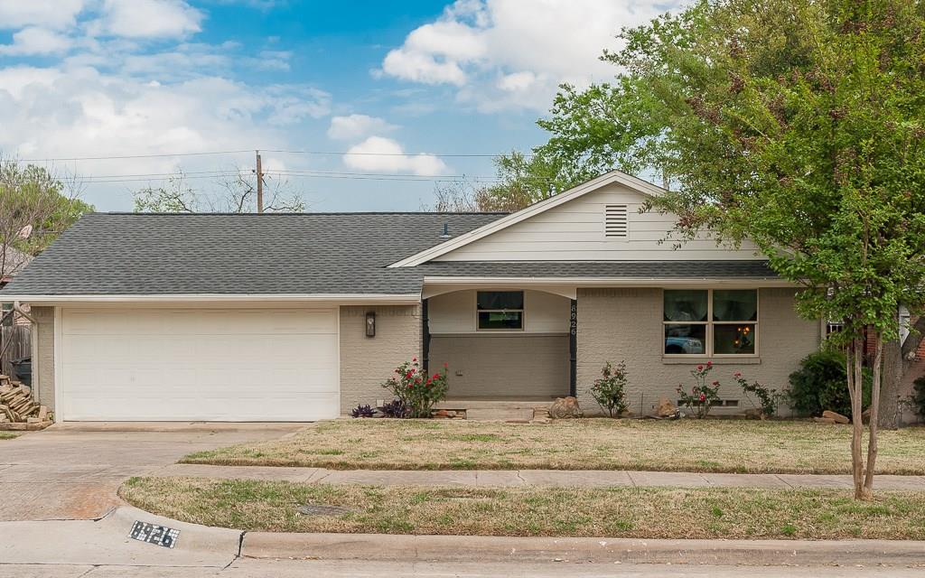 a view of a white house with a yard and plants
