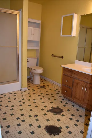 a bathroom with a sink a toilet and shower