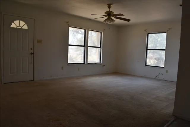 an empty room with windows and cabinet