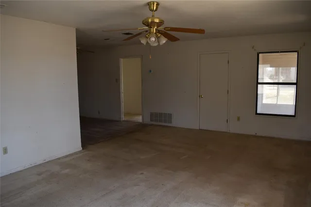 a view of a livingroom with a ceiling fan and window