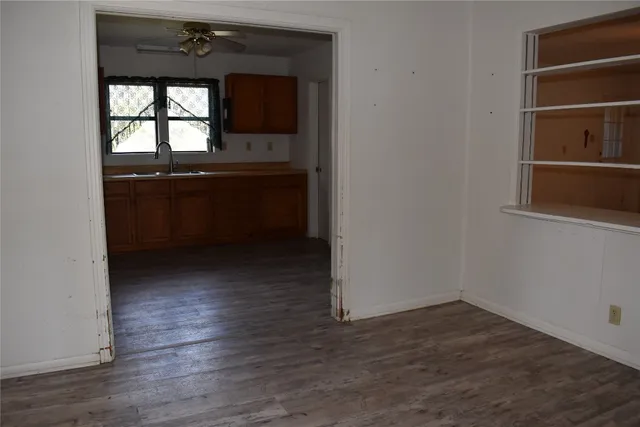 an empty room with wooden floor and a window