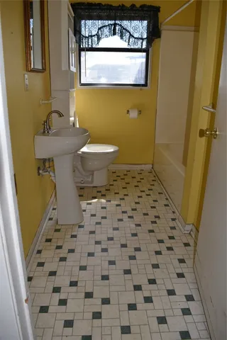 a bathroom with a sink a toilet and a mirror