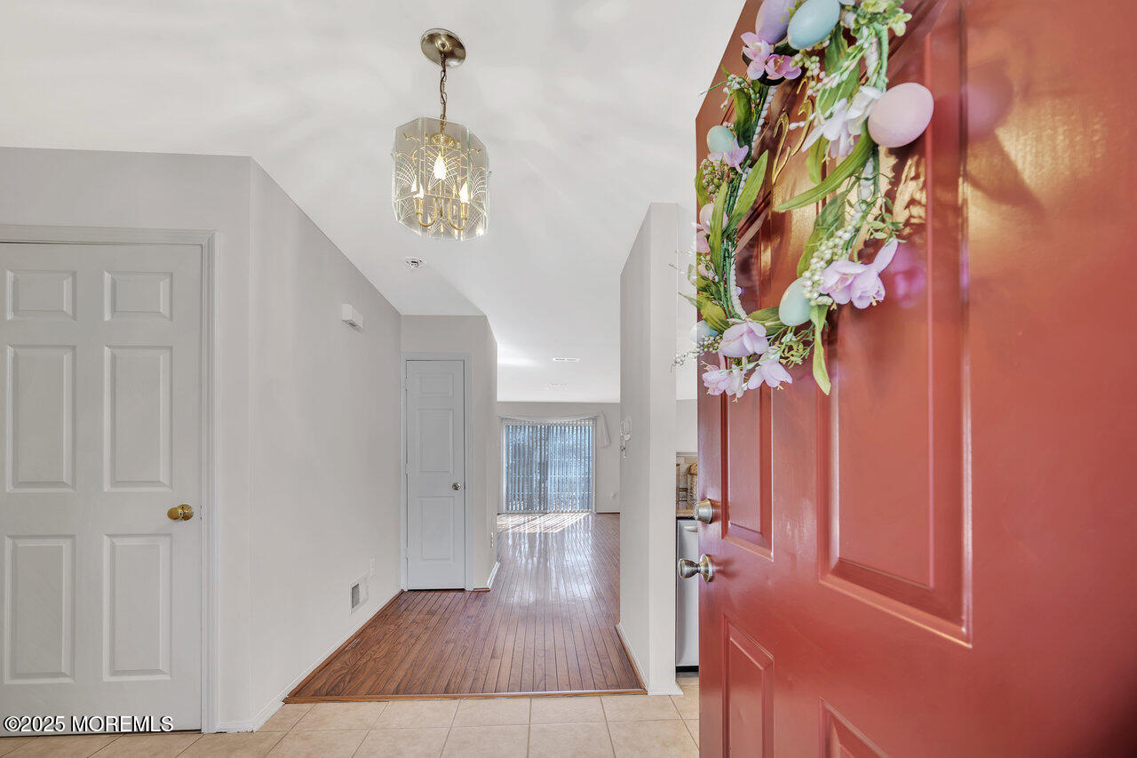 Undisclosed Address Holmdel, NJ 07733 - Photo 4 of 28 wooden floor in an entryway with a chandelier