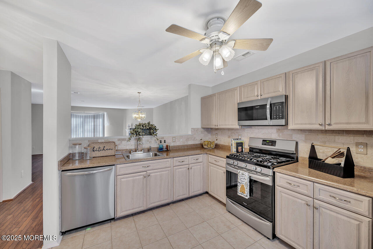 Undisclosed Address Holmdel, NJ 07733 - Photo 7 of 28 a kitchen with stainless steel appliances a sink stove and microwave