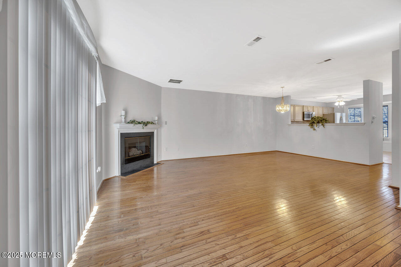 Undisclosed Address Holmdel, NJ 07733 - Photo 9 of 28 a view of empty room with wooden floor and fireplace